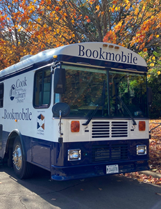 The Bookmobile parked in front of beautiful fall leaves.